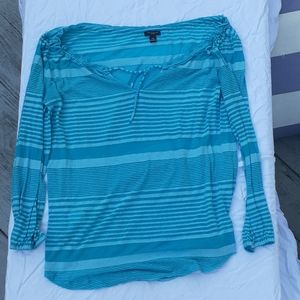 An aqua blue stripped long sleeved beach cover up